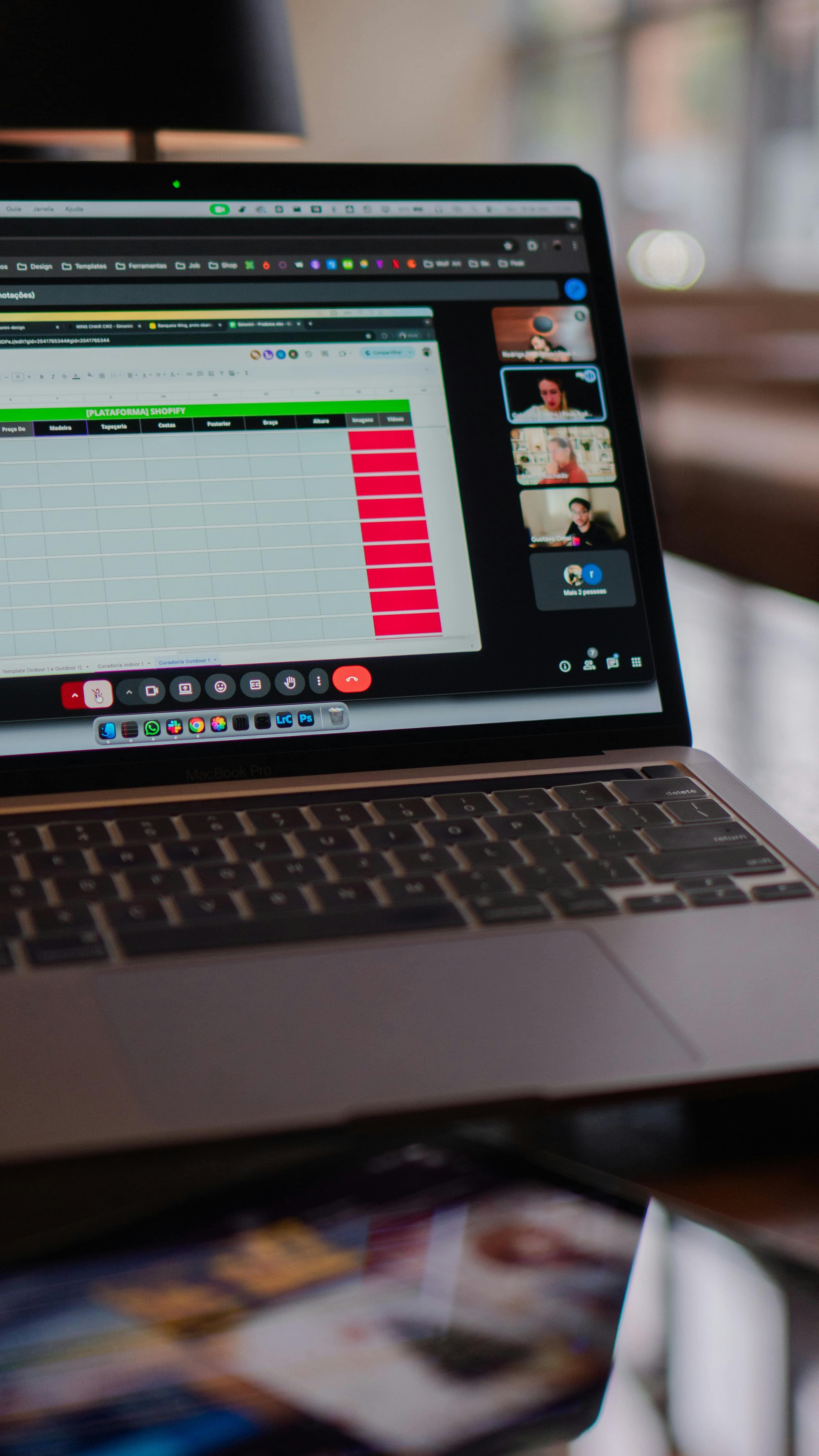 Laptop screen showing a remote meeting on an office desk.